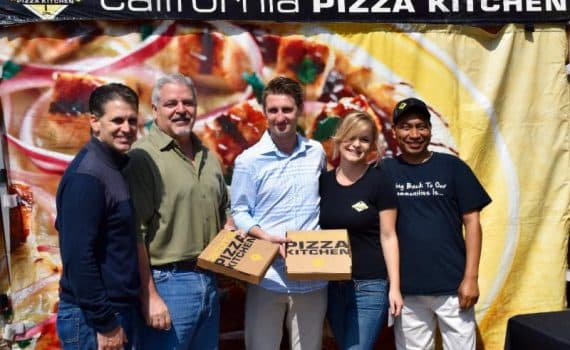 Sterling employees posing for camera with California Pizza Kitchen pizza boxes